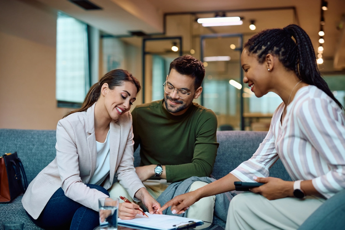 People discussing paperwork in a modern office.